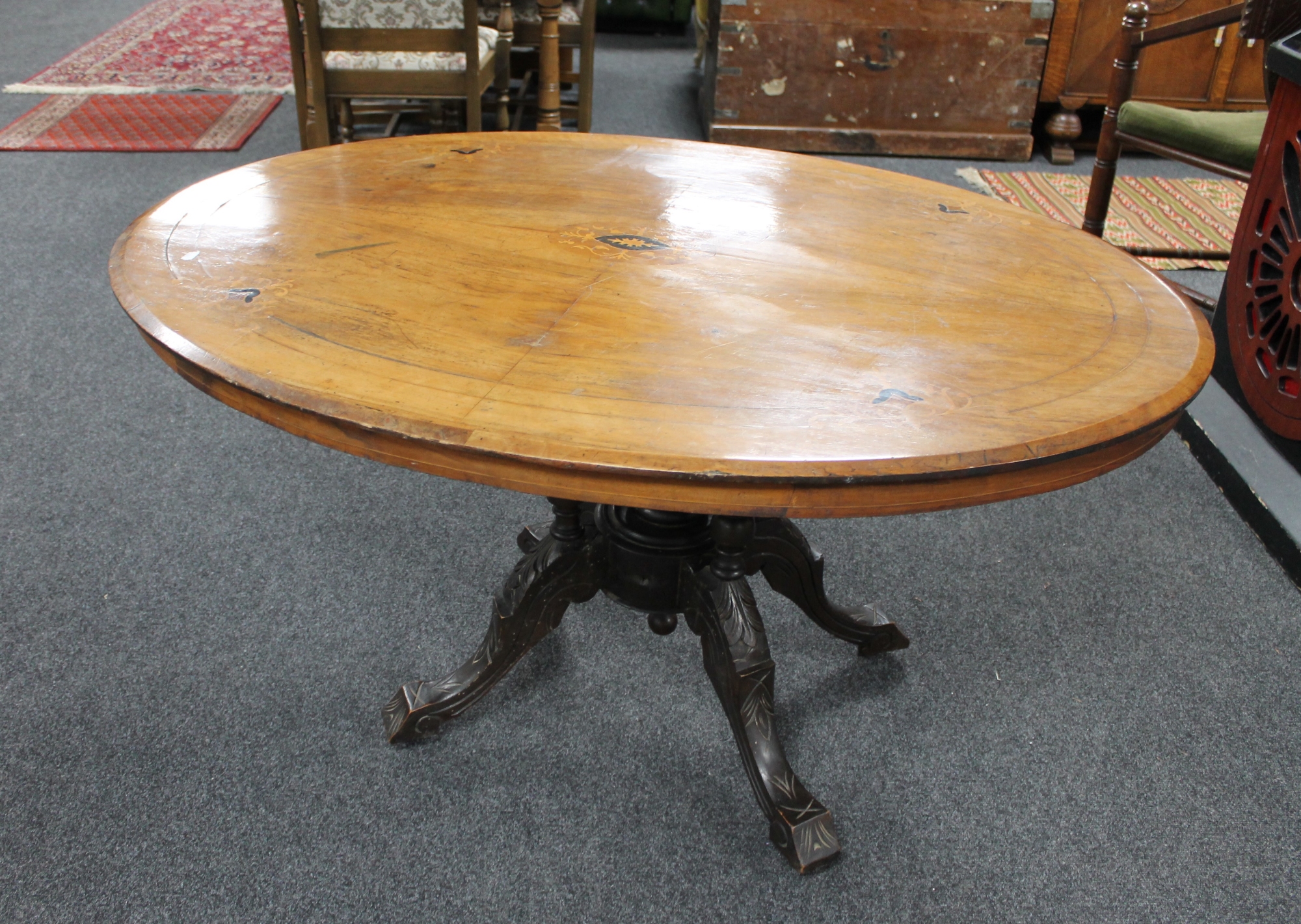 A Victorian inlaid oval breakfast table on carved four way support