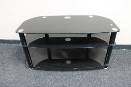 A black glass three tier TV stand