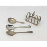 A silver five bar toast rack and three spoons.