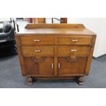 A 1930's oak double door sideboard fitted with four drawers