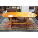 A shaped beech twin pedestal dining table with under stretcher