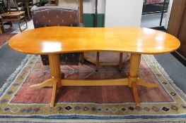 A shaped beech twin pedestal dining table with under stretcher