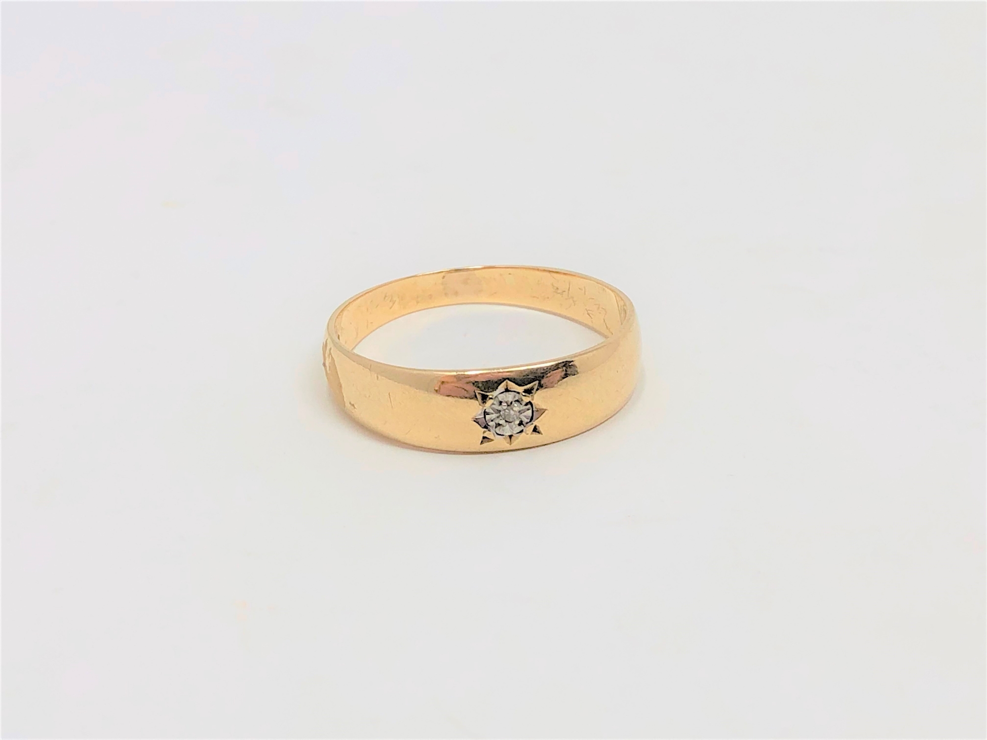 A 9ct gold band ring set with a small diamond, size T. CONDITION REPORT: 2.4g.