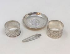 Two silver napkin rings, silver dish inset with Hong Kong $1 coin and a continental silver clip.