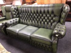 A green buttoned leather three seater wing backed settee