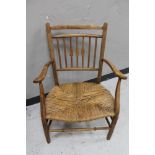 An early 20th century rush seated kitchen armchair
