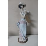 A Lladro figure of a female standing with tea cup