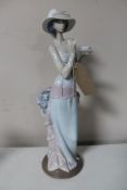 A Lladro figure of a female standing with tea cup
