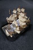 A tray of four wooden models of tall ships, HMS Victory and Cutty Sark,