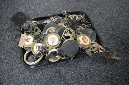 A tray of horse brasses on leather straps