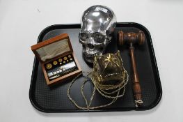 An auctioneer's wooden gavel, a cast alloy skull,