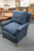 An early twentieth century armchair in blue fabric on claw and ball feet