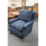 An early twentieth century armchair in blue fabric on claw and ball feet