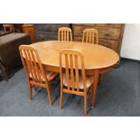 A twentieth century oval teak extending dining table and four chairs