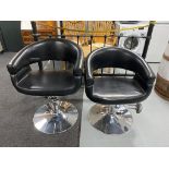 A pair of hydraulic salon armchairs