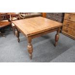 An early twentieth century square oak pull out dining table