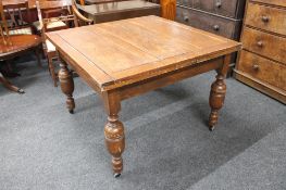 An early twentieth century square oak pull out dining table