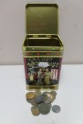 A metal tin of pre decimal British coins and foreign coins