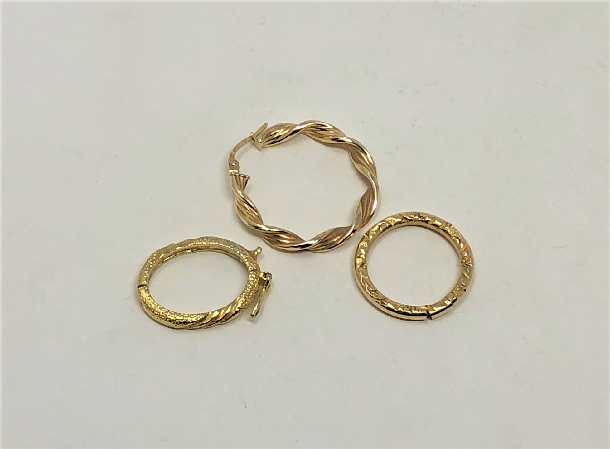 Three pieces of yellow metal - 9ct gold earring and two further hoops, 5.2g.