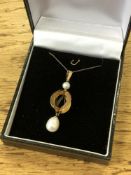 A pearl pendant set in yellow gold on chain