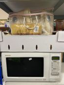 A Sharp quartz dual grill microwave together with a box of bedding,