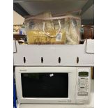 A Sharp quartz dual grill microwave together with a box of bedding,