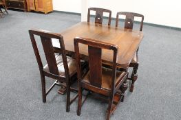 An oak early 20th century pull out dining table and four chairs