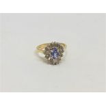 A diamond and tanzanite cluster ring set in 14ct yellow gold.