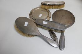 A box of five silver backed dressing table hand mirrors and brushes