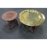 A folding Eastern carved hardwood table and a further brass topped table