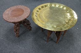 A folding Eastern carved hardwood table and a further brass topped table