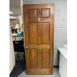 A wooden exterior door with brass fixtures