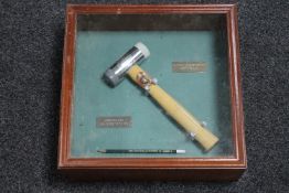 A wooden display box with presentation hammer and pencil
