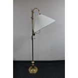 An adjustable brass floor lamp with shade