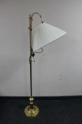 An adjustable brass floor lamp with shade