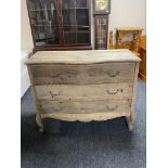 An antique style pine serpentine fronted three drawer chest