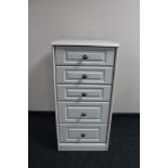 A white narrow five drawer chest