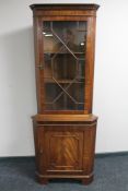 A reproduction mahogany corner display cabinet