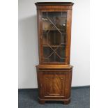 A reproduction mahogany corner display cabinet