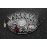 An antique silver plated twin handled tray of drinking glasses, cruets part sets,