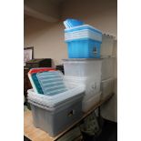A quantity of plastic storage crates, some with lids.