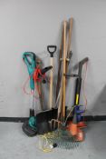 A plastic tub containing gardening tools, two electric strimmers,