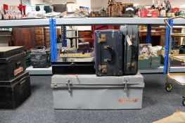 An early twentieth century tin trunk together with two mid century luggage cases and a metal deed