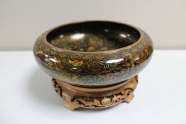 A cloisonne bowl on wooden stand width 20.5cm.