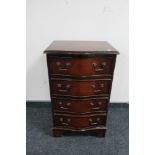 An inlaid mahogany serpentine fronted four drawer chest