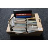 A box of 20th century postcards and three albums of stamps of the world