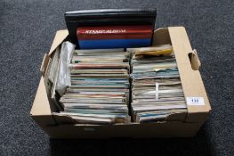 A box of 20th century postcards and three albums of stamps of the world