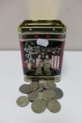 A metal tin of pre decimal British coins and foreign coins