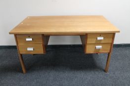 A mid 20th century teak desk fitted with four drawers