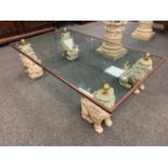 A contemporary glass coffee table foo dog supports with 154 cm x 93 cm